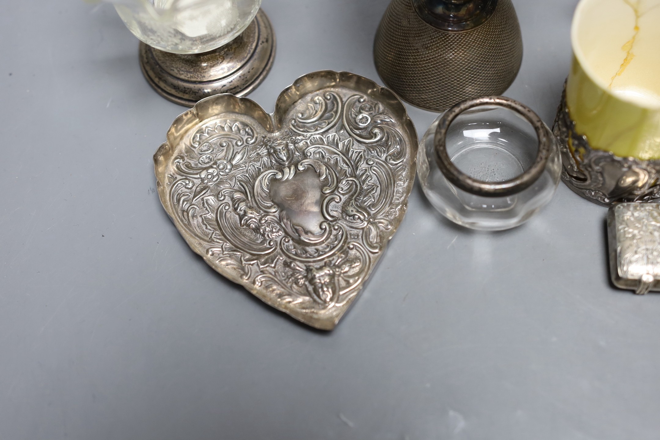 A small group of collectable items including a silver stationary rack, Laurence Emanuel, Birmingham, 1901, height 9.7cm, a silver communion goblet, silver mounted porcelain coffee cup, silver mounted glass vase, silver v